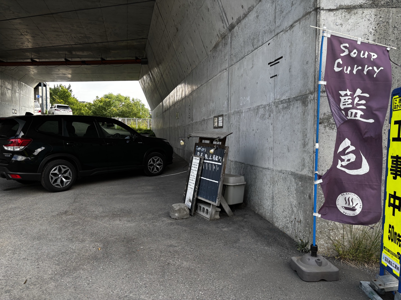 藍色の高架下駐車場。のぼりが目印で、斜めに停めるスタイル
