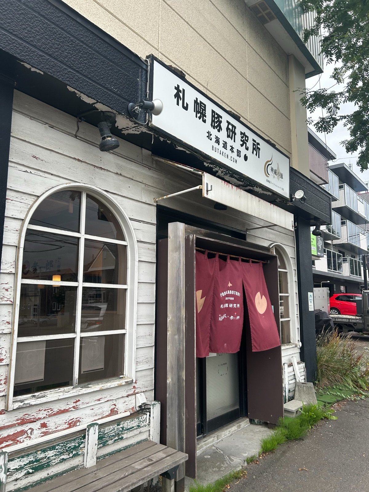 札幌豚研究所の外観。白い洋館風の建物に「札幌豚研究所 北海道本部」の看板