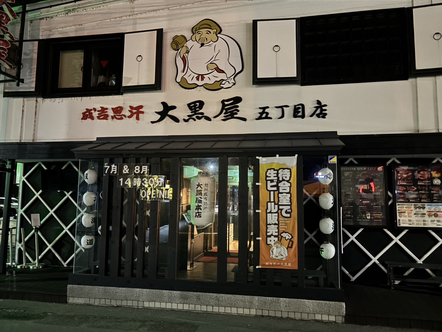 夜の成吉思汗 大黒屋 五丁目店の外観。白壁に大黒天のイラスト看板と「成吉思汗 大黒屋 五丁目店」の文字