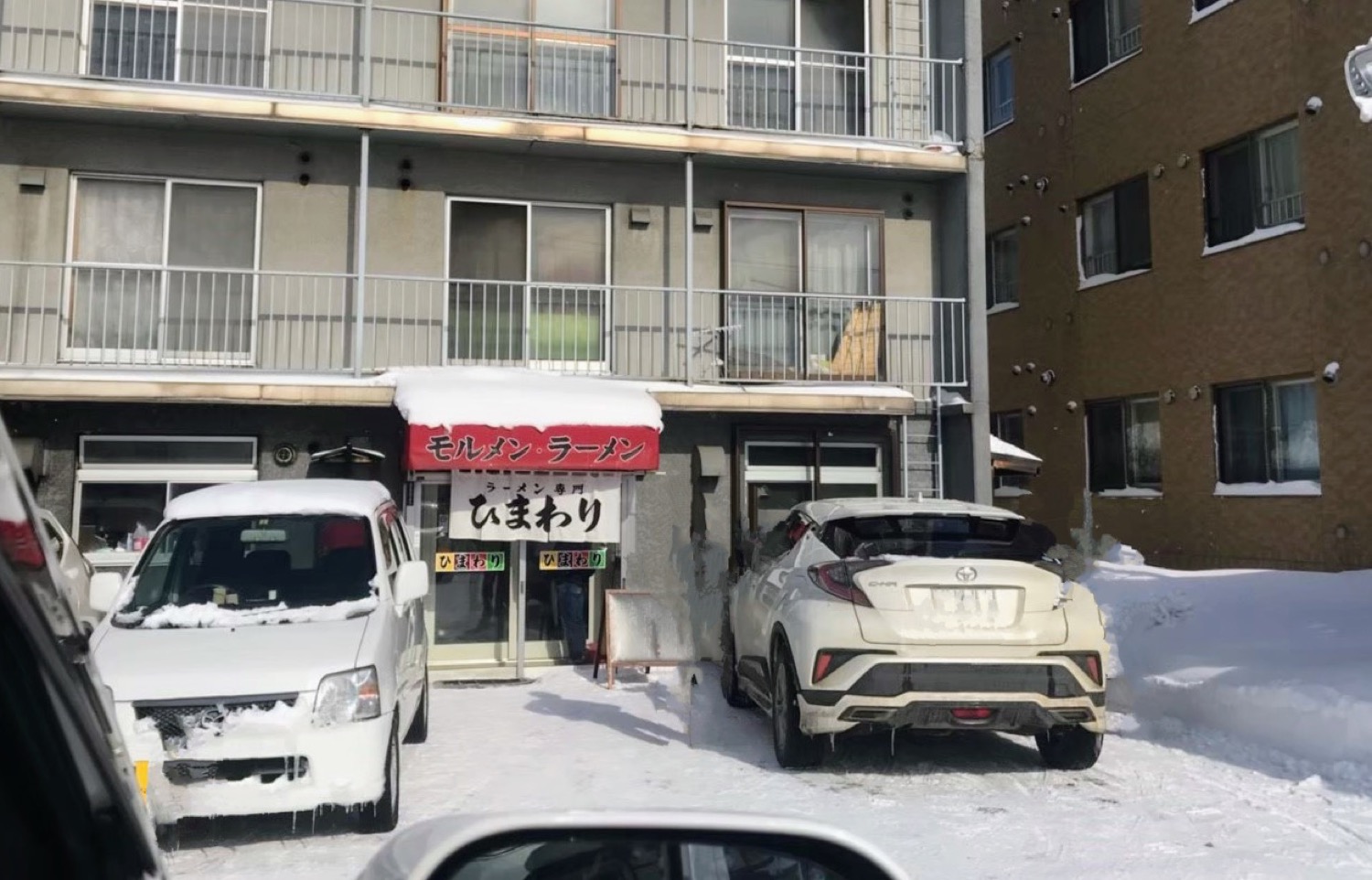 雪の日のラーメン専門ひまわりの外観。赤い庇に「モルメン・ラーメン」の文字