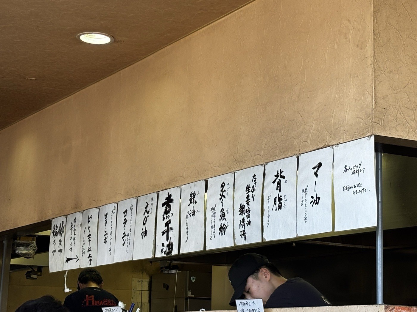 ラーメン常の無料トッピングの札。マー油、背脂、炙り魚粉などが並ぶ