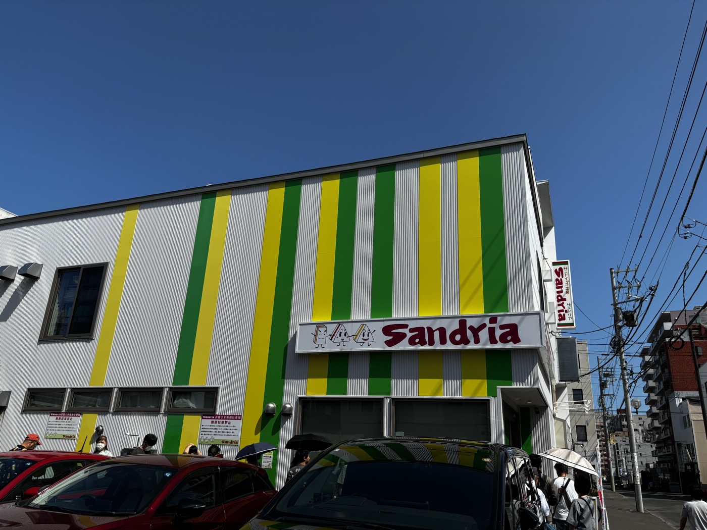 緑と黄色のストライプが目印のサンドリア本店の外観