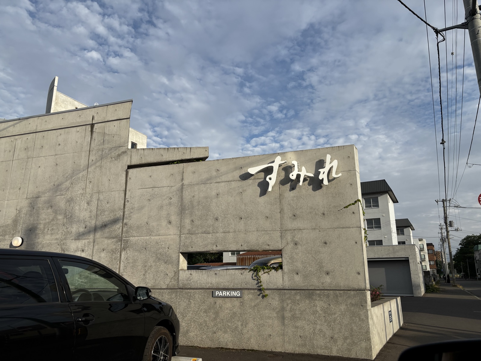 すみれ 中の島本店の外観。コンクリート壁に「すみれ」のロゴ