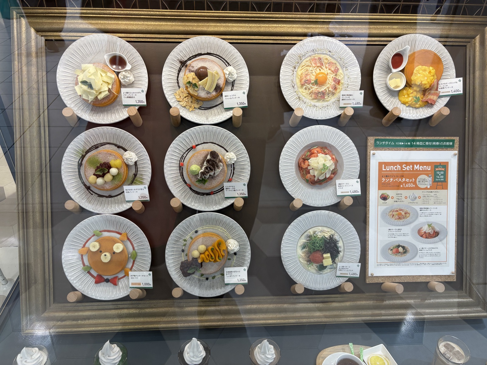 店頭のメニューサンプル。パンケーキとパスタが値段付きで並ぶ
